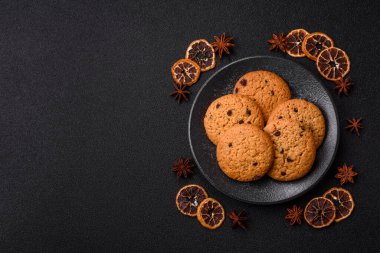 Yemek, yulaf ezmesi, çikolatalı üzümlü kurabiye, tatlı ya da kahvaltı pastası. Yulaf ezmeli çikolatalı kurabiyeler tasarımınız için gıda arka planıdır.