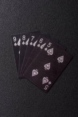 Kumarhanede poker oynuyorum. Fişler, bahisler ve risklerle. Kartlar ve çipler siyah üzerine tasarımın için arka plan olarak hissedildi