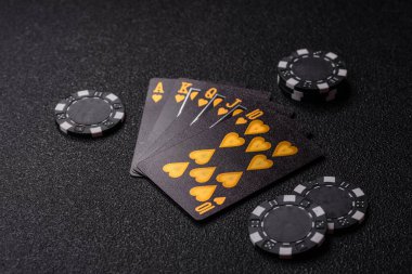Kumarhanede poker oynuyorum. Fişler, bahisler ve risklerle. Kartlar ve çipler siyah üzerine tasarımın için arka plan olarak hissedildi