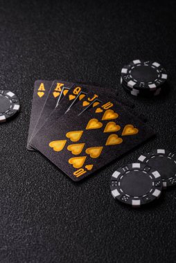Kumarhanede poker oynuyorum. Fişler, bahisler ve risklerle. Kartlar ve çipler siyah üzerine tasarımın için arka plan olarak hissedildi