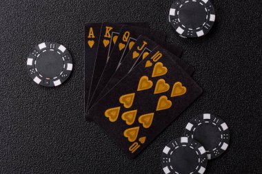 Kumarhanede poker oynuyorum. Fişler, bahisler ve risklerle. Kartlar ve çipler siyah üzerine tasarımın için arka plan olarak hissedildi
