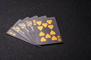 Kumarhanede poker oynuyorum. Fişler, bahisler ve risklerle. Kartlar ve çipler siyah üzerine tasarımın için arka plan olarak hissedildi