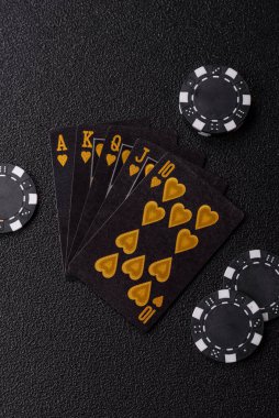 Kumarhanede poker oynuyorum. Fişler, bahisler ve risklerle. Kartlar ve çipler siyah üzerine tasarımın için arka plan olarak hissedildi