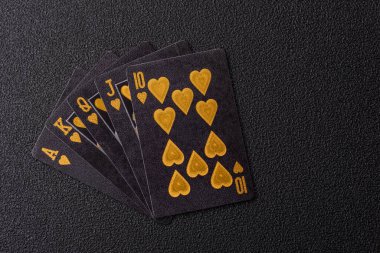 Kumarhanede poker oynuyorum. Fişler, bahisler ve risklerle. Kartlar ve çipler siyah üzerine tasarımın için arka plan olarak hissedildi