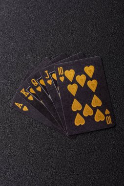 Kumarhanede poker oynuyorum. Fişler, bahisler ve risklerle. Kartlar ve çipler siyah üzerine tasarımın için arka plan olarak hissedildi