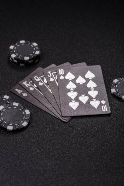 Kumarhanede poker oynuyorum. Fişler, bahisler ve risklerle. Kartlar ve çipler siyah üzerine tasarımın için arka plan olarak hissedildi