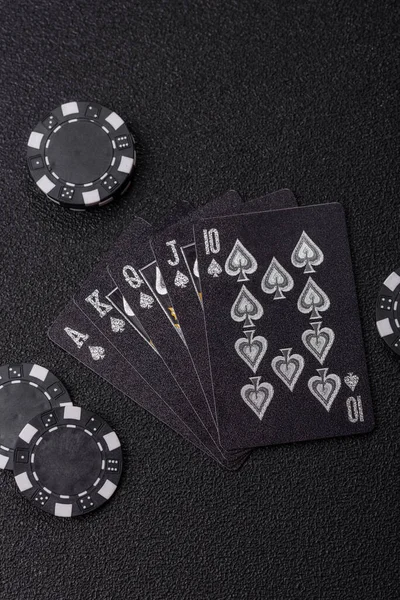 Kumarhanede poker oynuyorum. Fişler, bahisler ve risklerle. Kartlar ve çipler siyah üzerine tasarımın için arka plan olarak hissedildi