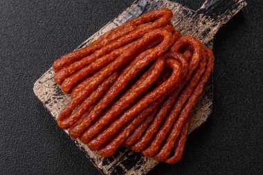 Tütsülenmiş kabinesi, ince salam sosisi, et çubukları veya aperatifler. Tasarımınız için gıda arka planı olarak Cabanossi sosisi.