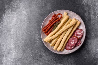 Grissini ekmeği, bir İtalyan buğday böreği, harika bir öğle yemeği atıştırmalığıdır. Grissini ekmek çubuklarını tasarımın için bir gıda arka planı olarak kullan