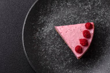 Ahududulu ya da çilekli cheesecake, çilekli bir dilim tatlı kırmızı kek. Tasarımınız için arkaplan olarak ahudududulu cheesecake.