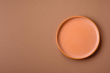 Masada boş bir seramik tabak, mutfak gereçleri. Tasarımınız için yiyecek arka planı olarak boş bir tabak
