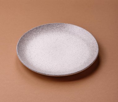 Masada boş bir seramik tabak, mutfak gereçleri. Tasarımınız için yiyecek arka planı olarak boş bir tabak