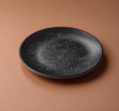 Masada boş bir seramik tabak, mutfak gereçleri. Tasarımınız için yiyecek arka planı olarak boş bir tabak