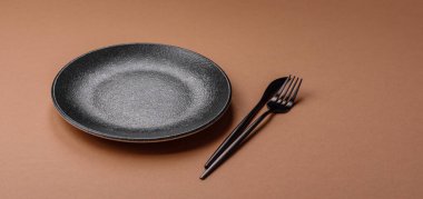 Masada boş bir seramik tabak, mutfak gereçleri. Tasarımınız için yiyecek arka planı olarak boş bir tabak