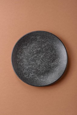 Masada boş bir seramik tabak, mutfak gereçleri. Tasarımınız için yiyecek arka planı olarak boş bir tabak