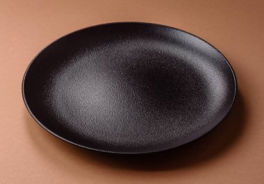 Masada boş bir seramik tabak, mutfak gereçleri. Tasarımınız için yiyecek arka planı olarak boş bir tabak