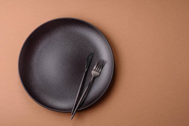 Masada boş bir seramik tabak, mutfak gereçleri. Tasarımınız için yiyecek arka planı olarak boş bir tabak