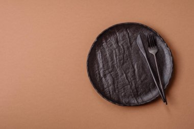 Masada boş bir seramik tabak, mutfak gereçleri. Tasarımınız için yiyecek arka planı olarak boş bir tabak