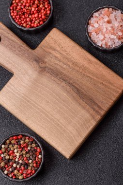 Ahşap, karanlık bir mutfak masasında tahta boş bir kesme tahtası. Tasarımınız için gıda arka planı olarak ahşap kesme tahtası