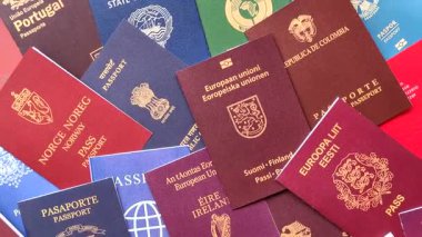 Farklı ülkelerin vatandaşlarının pasaportları, çeşitli ülkelerin pasaportlarından oluşan arka plan.