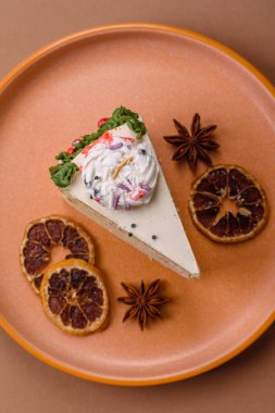 Noel süsü ve meyve aromalı bir dilim tatlı pasta. Tasarımın için yemek arkaplanı olarak bir dilim pasta