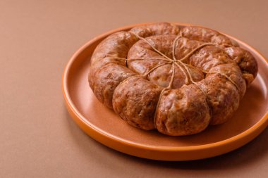 Spiral ya da salyangoz şeklinde ızgara sosis, baharat ve bitkilerle yapılmış tavuk ya da domuz eti yemeği. Dizaynınız için yemek arkaplanı olarak sarmal ya da salyangoz sosisi