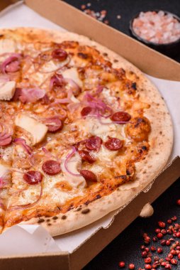 Akşam yemeğinde sosisli, tavuklu ve peynirli İtalyan pizzası. Tasarımınız için arka plan olarak sosisli pizza.