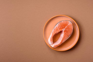 Balık, çiğ somon bifteği, tuzlu, baharatlı ve otlu ızgara için taze deniz ürünleri. Tasarımın için yemek arkaplanı olarak çiğ somon bifteği.