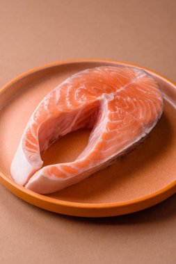 Balık, çiğ somon bifteği, tuzlu, baharatlı ve otlu ızgara için taze deniz ürünleri. Tasarımın için yemek arkaplanı olarak çiğ somon bifteği.