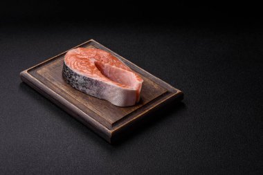 Balık, çiğ somon bifteği, tuzlu, baharatlı ve otlu ızgara için taze deniz ürünleri. Tasarımın için yemek arkaplanı olarak çiğ somon bifteği.