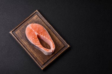 Balık, çiğ somon bifteği, tuzlu, baharatlı ve otlu ızgara için taze deniz ürünleri. Tasarımın için yemek arkaplanı olarak çiğ somon bifteği.