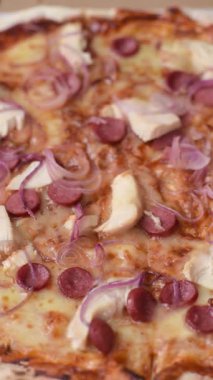 Akşam yemeğinde sosisli, tavuklu ve peynirli İtalyan pizzası. Tasarımınız için arka plan olarak sosisli pizza.