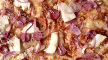 Akşam yemeğinde sosisli, tavuklu ve peynirli İtalyan pizzası. Tasarımınız için arka plan olarak sosisli pizza.