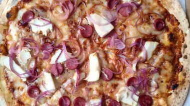 Akşam yemeğinde sosisli, tavuklu ve peynirli İtalyan pizzası. Tasarımınız için arka plan olarak sosisli pizza.