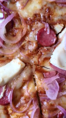 Akşam yemeğinde sosisli, tavuklu ve peynirli İtalyan pizzası. Tasarımınız için arka plan olarak sosisli pizza.