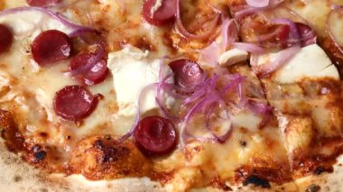 Akşam yemeğinde sosisli, tavuklu ve peynirli İtalyan pizzası. Tasarımınız için arka plan olarak sosisli pizza.