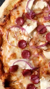 Akşam yemeğinde sosisli, tavuklu ve peynirli İtalyan pizzası. Tasarımınız için arka plan olarak sosisli pizza.