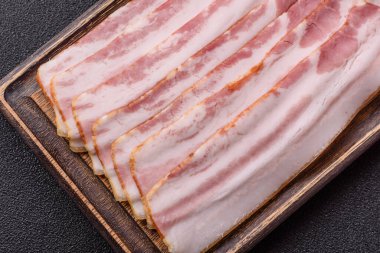 Çiğ domuz pastırması, jambon, jambon ya da jambon dilimleri. Tasarımın için yemek arkaplanı olarak çiğ pastırma dilimleri.