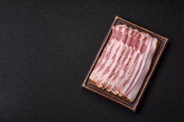 Çiğ domuz pastırması, jambon, jambon ya da jambon dilimleri. Tasarımın için yemek arkaplanı olarak çiğ pastırma dilimleri.