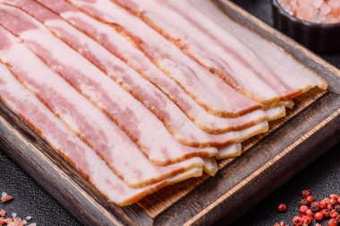Çiğ domuz pastırması, jambon, jambon ya da jambon dilimleri. Tasarımın için yemek arkaplanı olarak çiğ pastırma dilimleri.