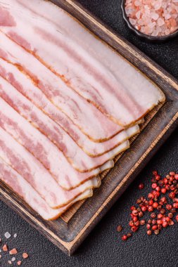 Çiğ domuz pastırması, jambon, jambon ya da jambon dilimleri. Tasarımın için yemek arkaplanı olarak çiğ pastırma dilimleri.