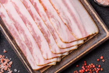 Çiğ domuz pastırması, jambon, jambon ya da jambon dilimleri. Tasarımın için yemek arkaplanı olarak çiğ pastırma dilimleri.