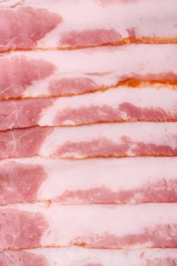 Çiğ domuz pastırması, jambon, jambon ya da jambon dilimleri. Tasarımın için yemek arkaplanı olarak çiğ pastırma dilimleri.