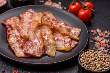 Kızarmış domuz pastırması, jambon, jambon veya jambon dilimleri. Tasarımın için arka plan olarak kızarmış pastırma dilimleri.