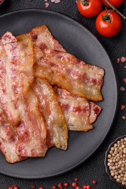 Kızarmış domuz pastırması, jambon, jambon veya jambon dilimleri. Tasarımın için arka plan olarak kızarmış pastırma dilimleri.