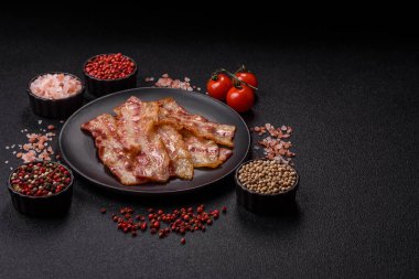 Kızarmış domuz pastırması, jambon, jambon veya jambon dilimleri. Tasarımın için arka plan olarak kızarmış pastırma dilimleri.