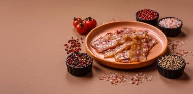 Kızarmış domuz pastırması, jambon, jambon veya jambon dilimleri. Tasarımın için arka plan olarak kızarmış pastırma dilimleri.