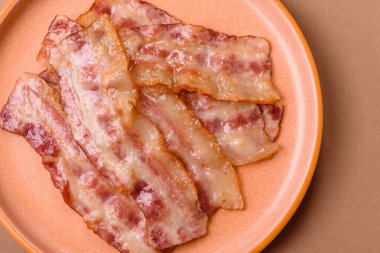 Kızarmış domuz pastırması, jambon, jambon veya jambon dilimleri. Tasarımın için arka plan olarak kızarmış pastırma dilimleri.