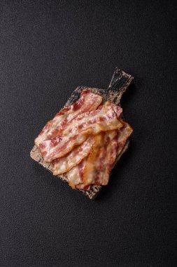 Kızarmış domuz pastırması, jambon, jambon veya jambon dilimleri. Tasarımın için arka plan olarak kızarmış pastırma dilimleri.