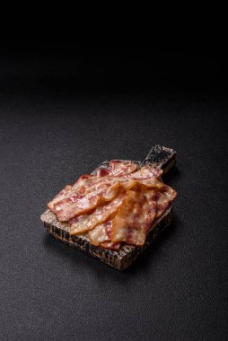 Kızarmış domuz pastırması, jambon, jambon veya jambon dilimleri. Tasarımın için arka plan olarak kızarmış pastırma dilimleri.
